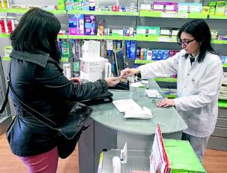Una clienta compra en una farmacia catalana. FERRAN NADEU