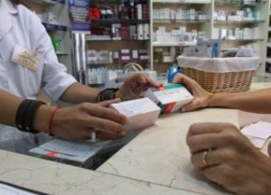 Una farmacéutica muestra un par de envases distintos a una usuaria. // FdV