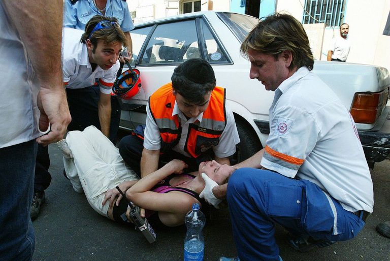 Israeli rescue workers help a woman who