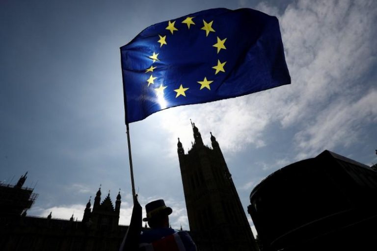 An anti-Brexit protester waves an EU flag opposite the Houses of Parliament in London