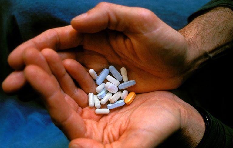 Man holding HIV medication cocktail, close-up