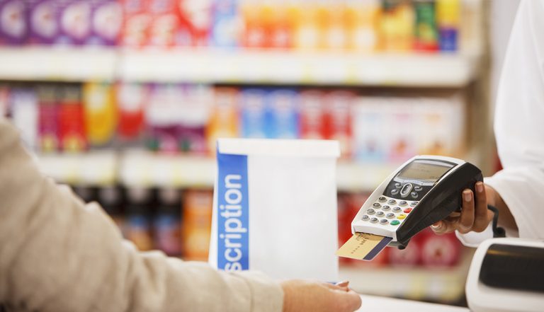 Pharmacist holding security device for customer in drug store