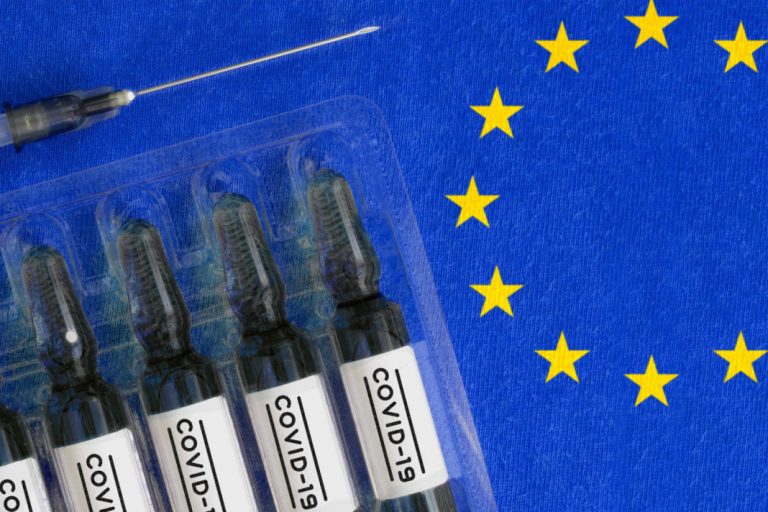 Coronavirus COVID-19 vaccine research concept. Struggle to stop epidemic of new virus by medical treatment. Syringe and ampules with COVID-19 label on European Union flag background