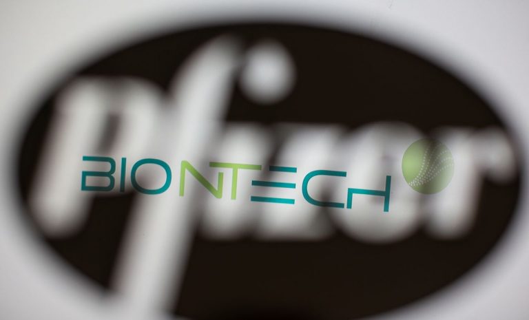 Biontech's logo is seen through a 3D-printed Pfizer logo in this illustration
