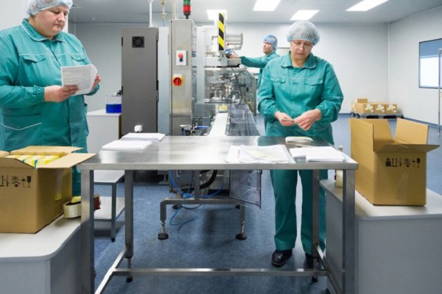 Empleados de una fábrica produciendo drogas en condiciones estériles.