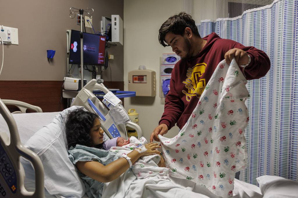 Fabián Méndez, de 20 años, y su novia Yolexi Cubillan, de 19 años, mientras sostiene a su recién nacido Derick Alexander Cubillan en el Centro Médico de la Universidad de Chicago el domingo 3 de septiembre de 2023 en Chicago.