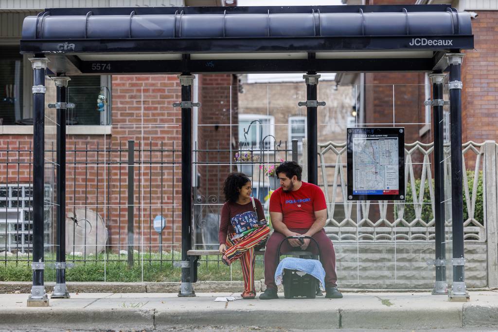 Yolexi Cubillan, de 19 años, y su novio Fabián Méndez, de 20, en una parada de autobús en West Garfield Boulevard mientras llevan a su recién nacido Derick Alexander Cubillan a una cita médica el jueves 7 de septiembre de 2023 en Chicago.