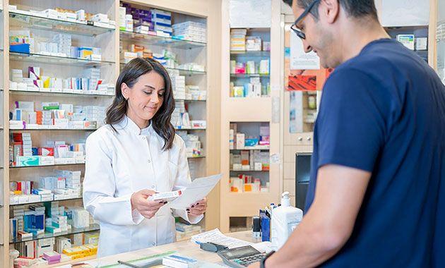 Foto de un cliente en una farmacia comprando un medicamento.