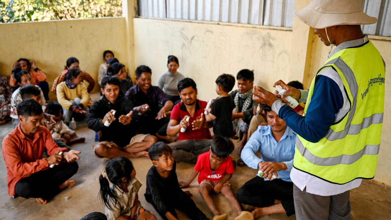 Un voluntario explica a los habitantes de la localidad de Pu Kesh, en Camboya, cómo emplear insecticida para prevenir la malaria el 16 de enero de 2025